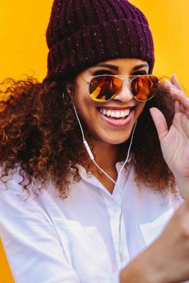 woman with curly hair and a beanie