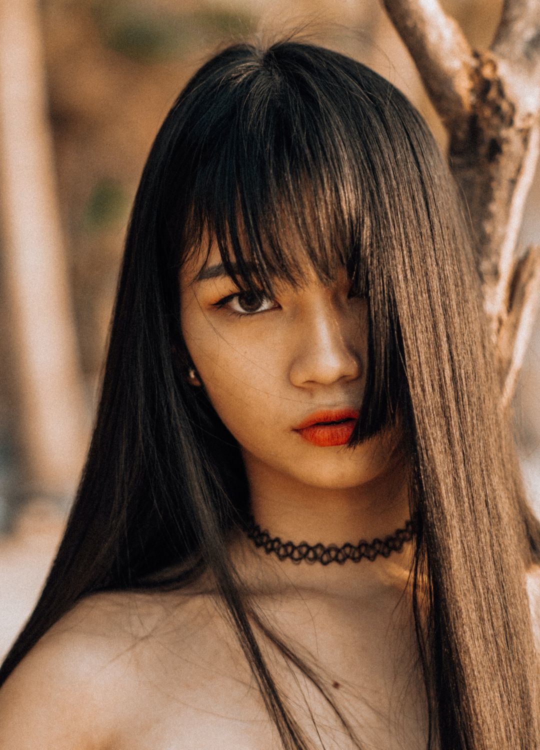 Kpop inspired hairstyle: woman with long sleek black hair, with a fringe and a blunt layer cut above the chin