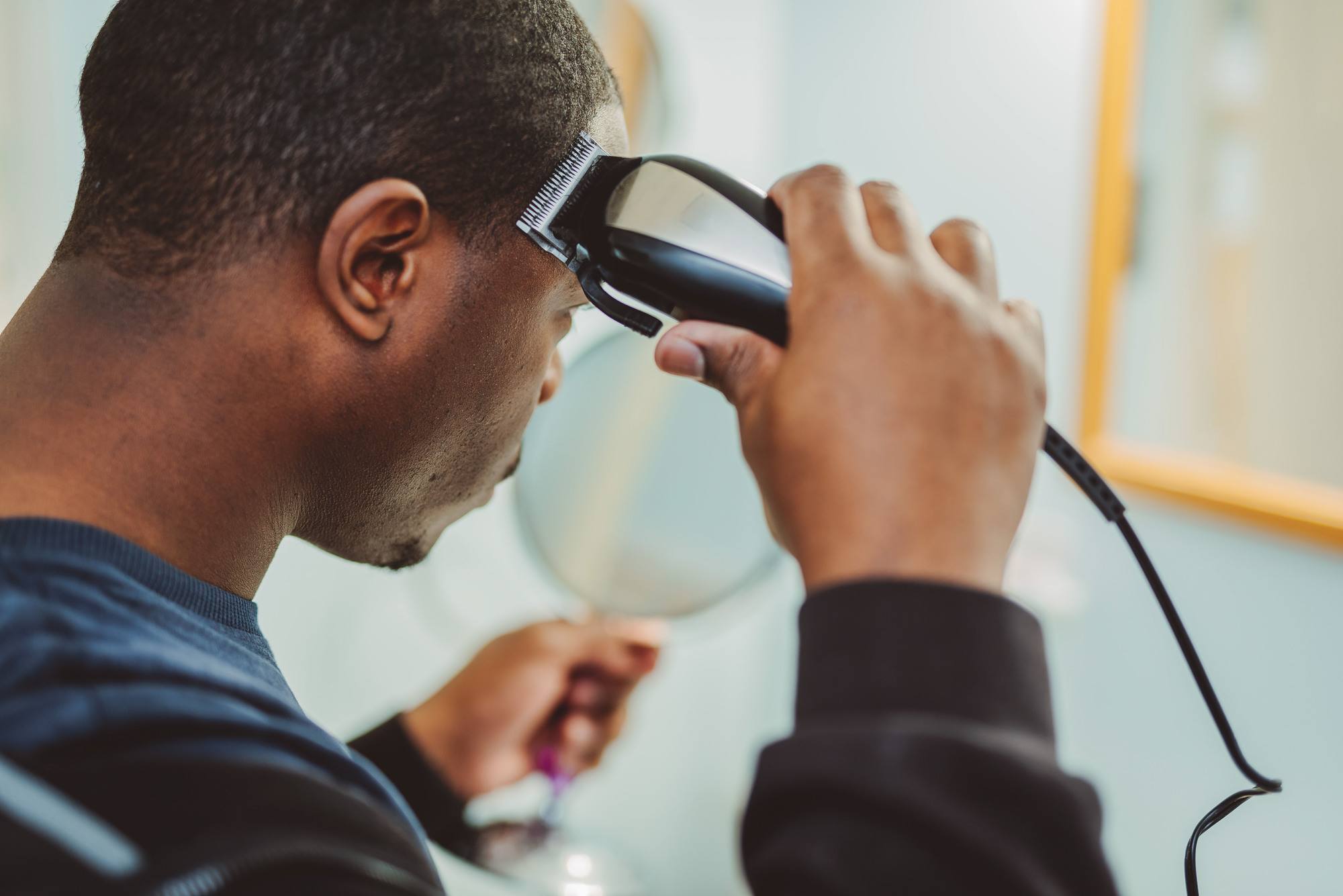 men's haircuts: man holding hair clippers