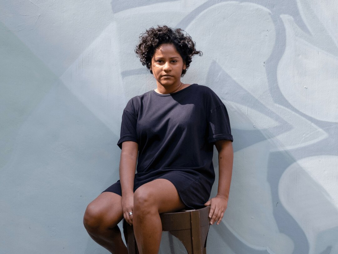 hairstyles for thick hair: woman with a short curly pixie cut hairstyle, sitting on a stool