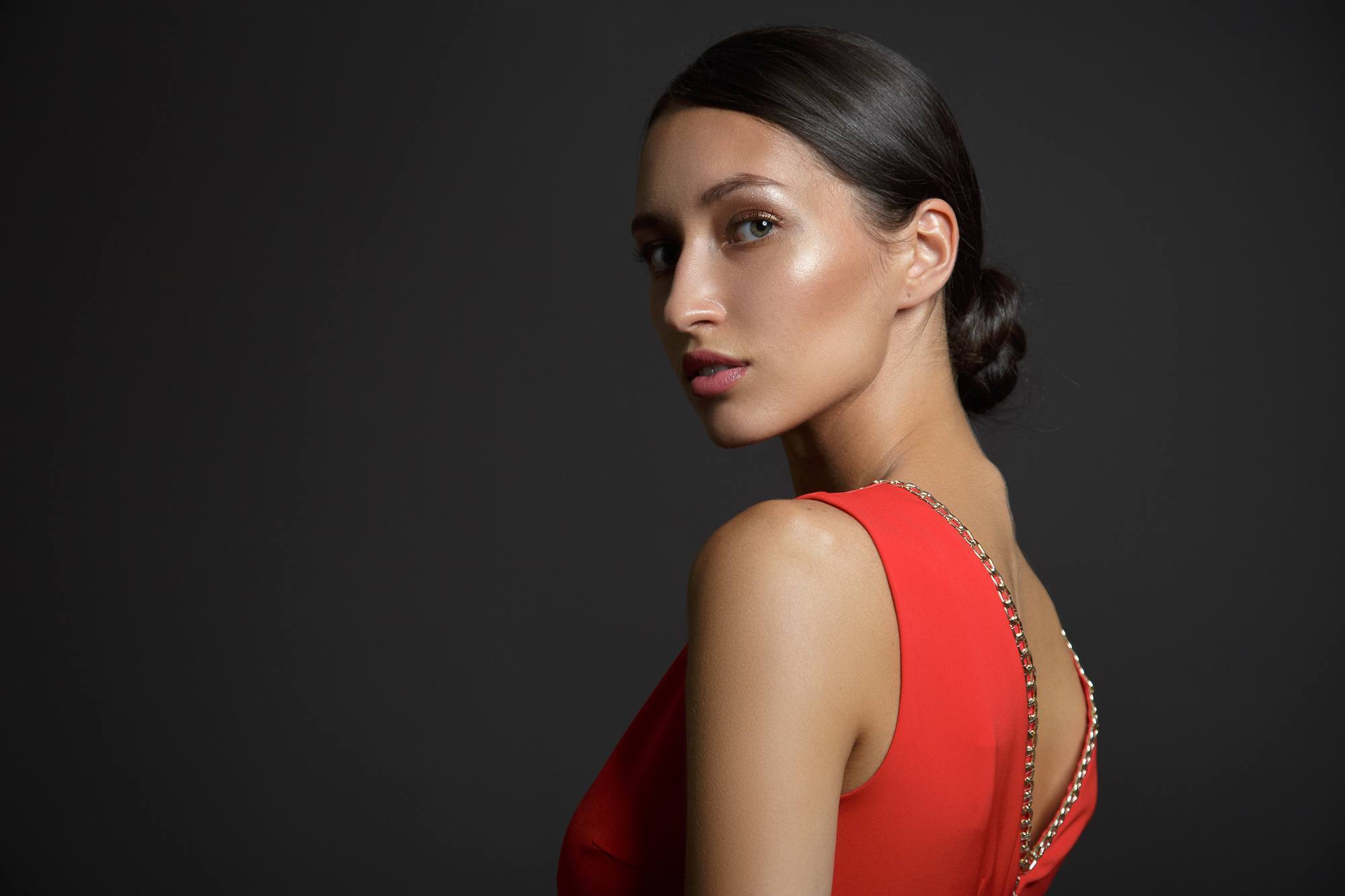 slick hairstyles: woman wearing a low bun with a slick centre part