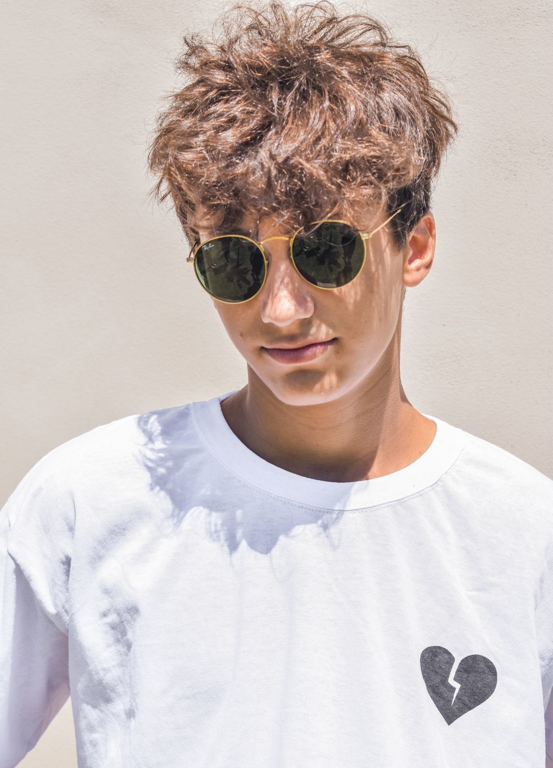 Kpop inspired hairstyle: man with a dark undercut and fluffy, wavy medium brown hair on top
