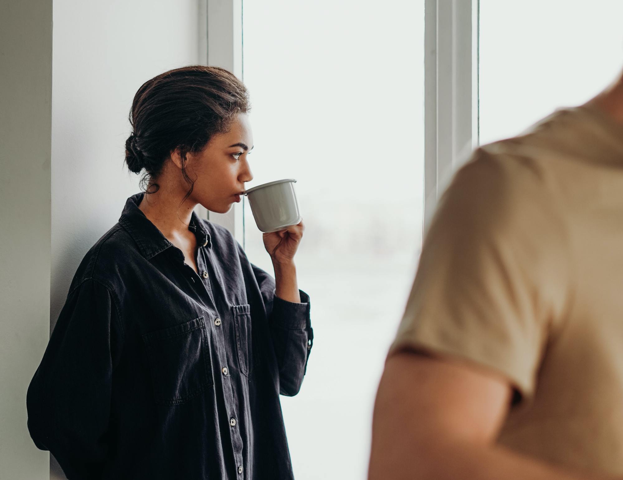 woman looking out the window working from home