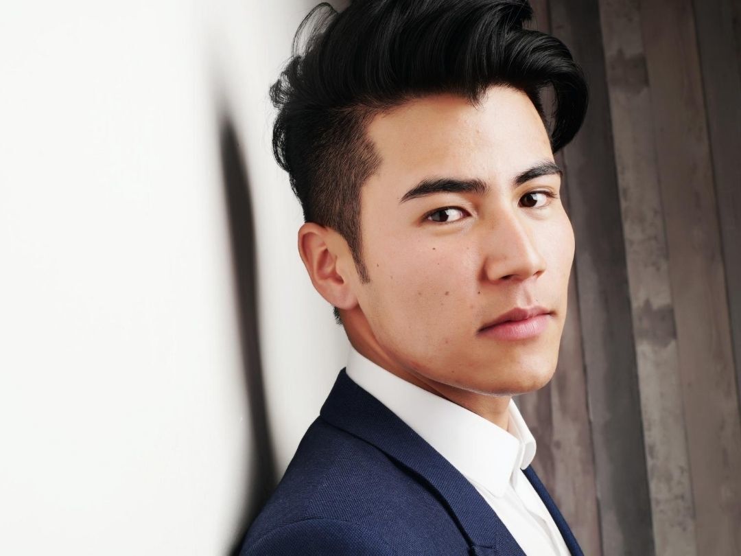 men's haircuts: man with a fresh haircut; short sides and sideburns, with a straigh, long top