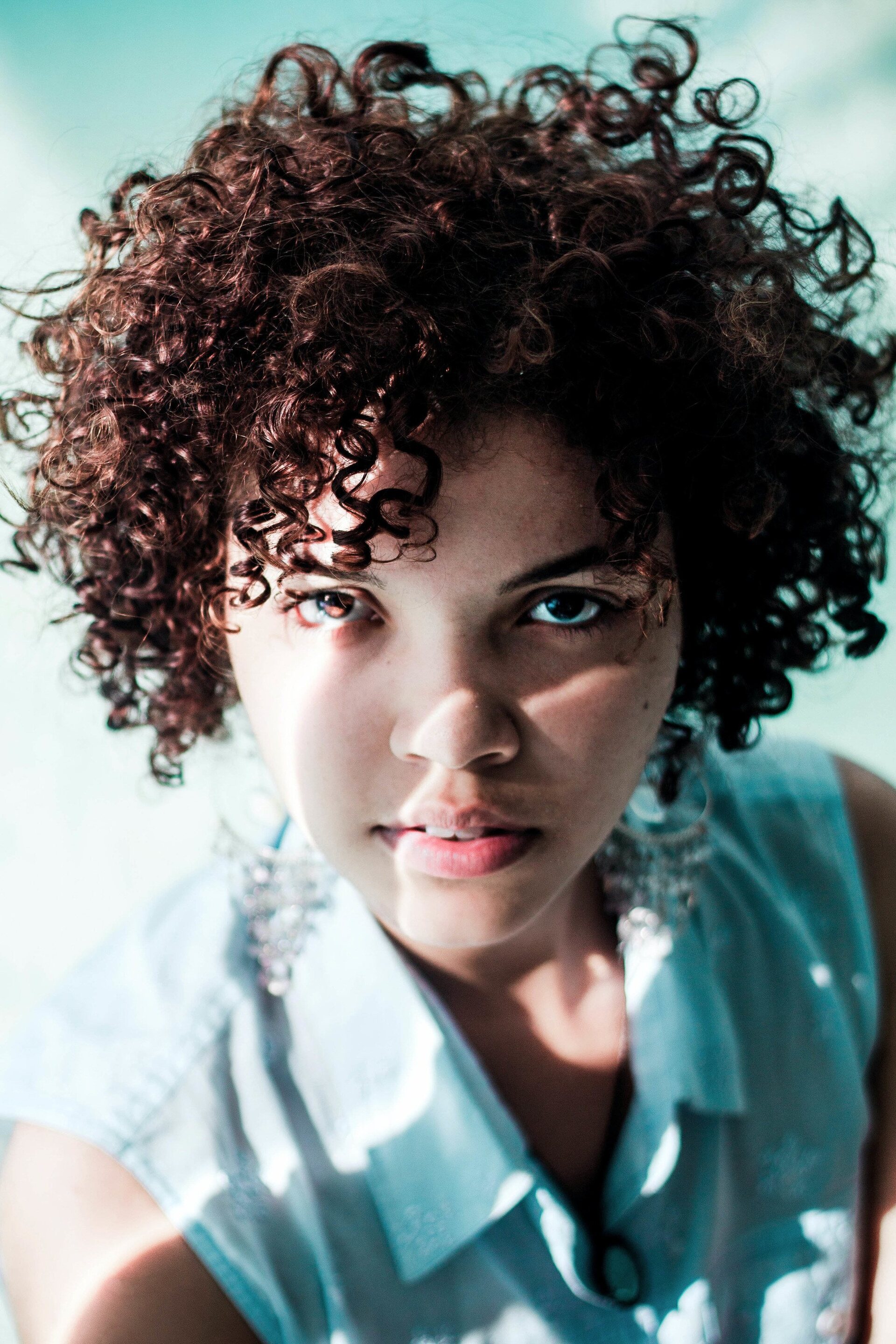 woman with a short, brown curly hairstyle