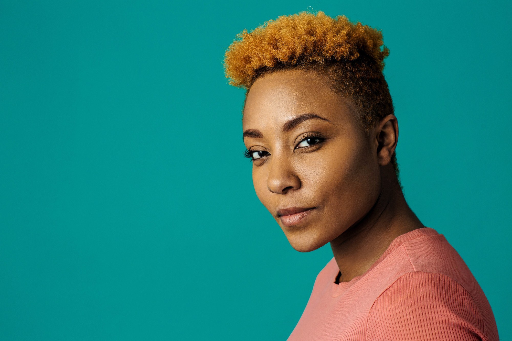 woman with short, light brown natural hair and shaved sides