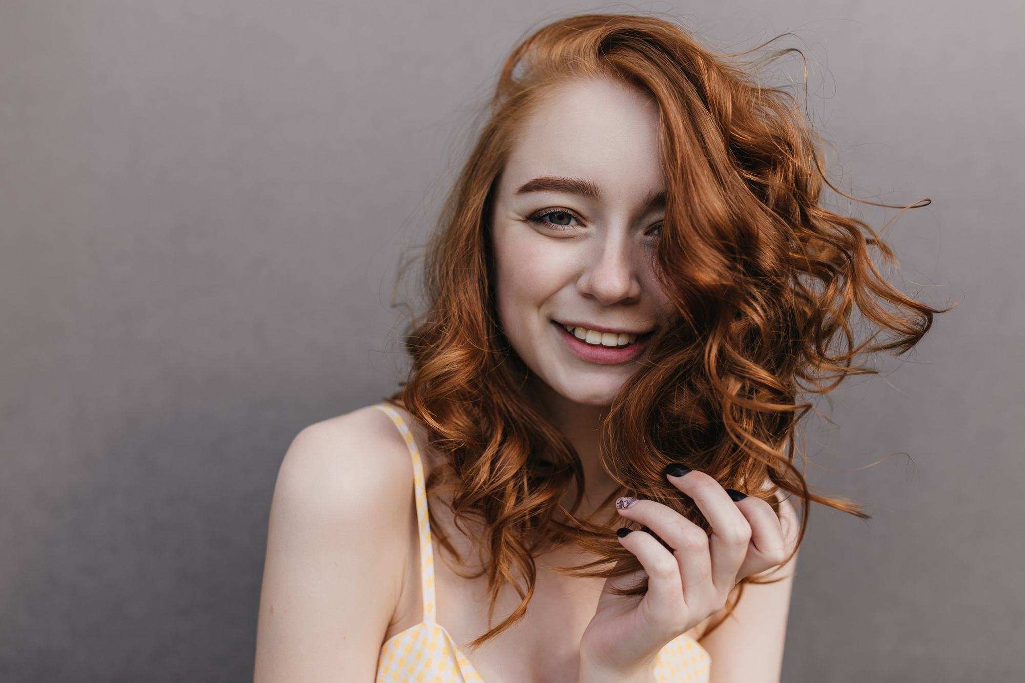 Woman with red hair ginger hair wavy curls lob haircut