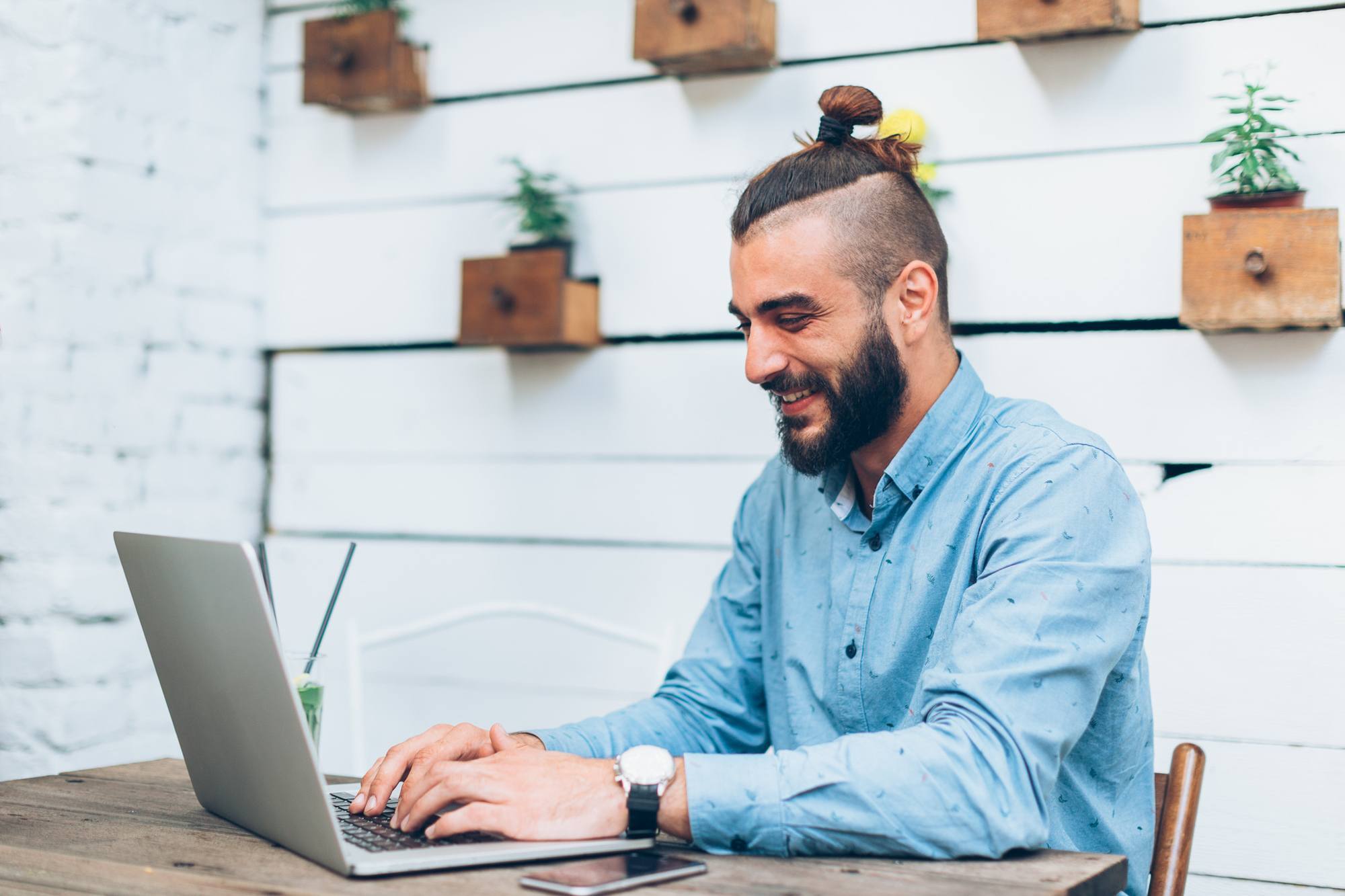 man with long hair bun shaved sides