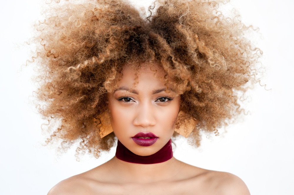 Girl with strawberry blonde curls brown roots hairstyle ideas