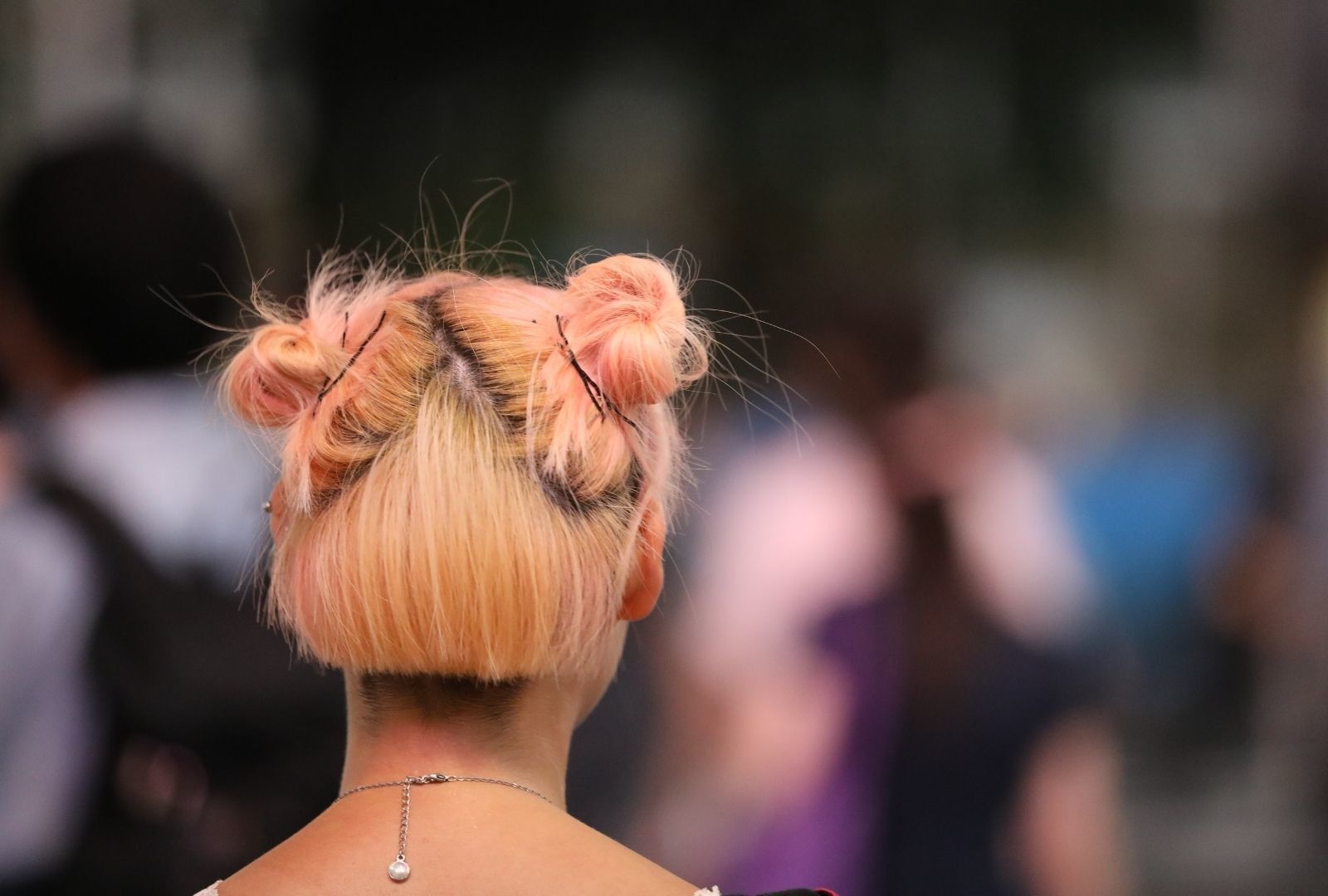 woman with short peach-coloured hair tied into half-up space buns