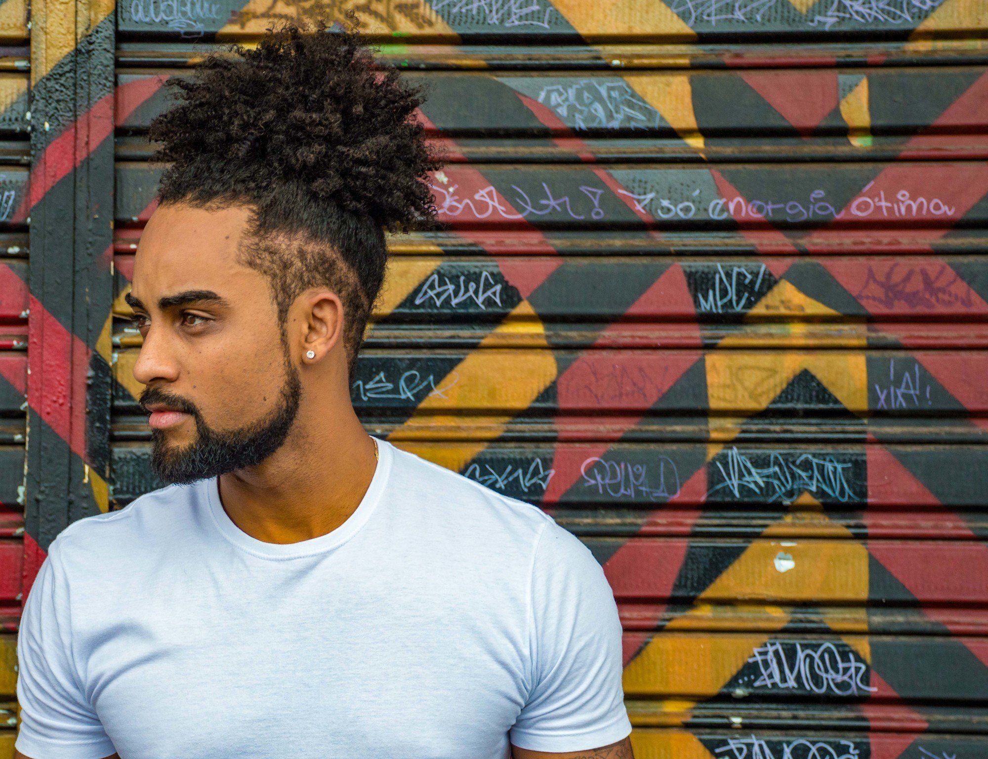 man with curly man bun and undercut
