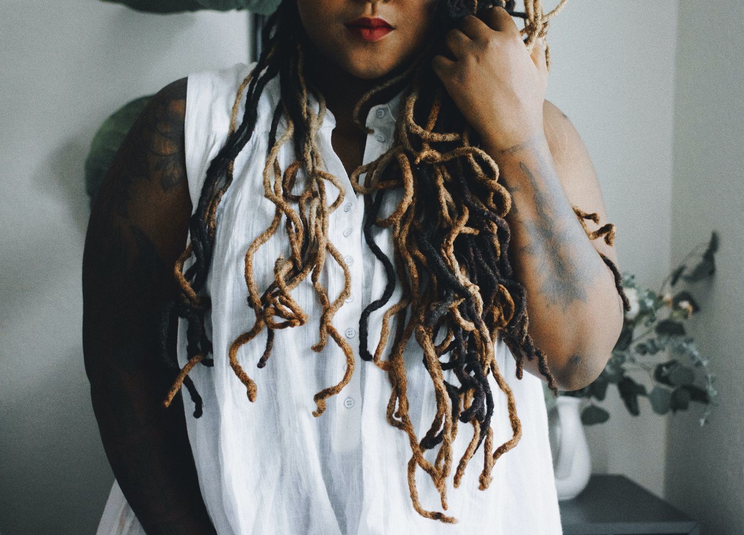 woman with long locs that are half dyed black, and half are bleached blonde