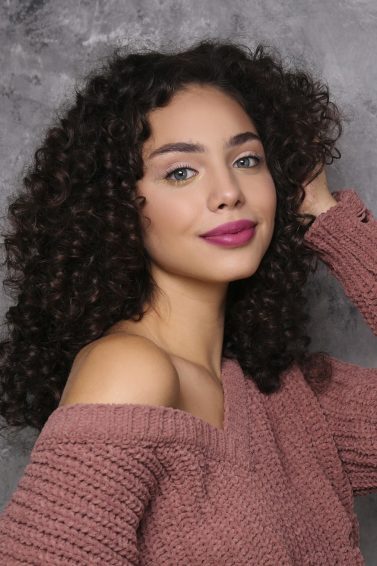 hair hacks for thick hair: woman with medium-length naturally curly hair cut into layers