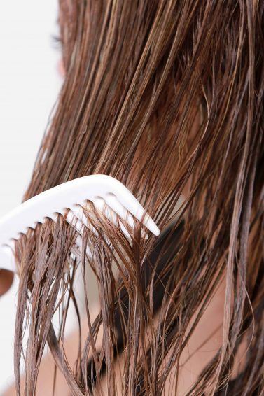heat damaged hair: close up shot of combing through hair