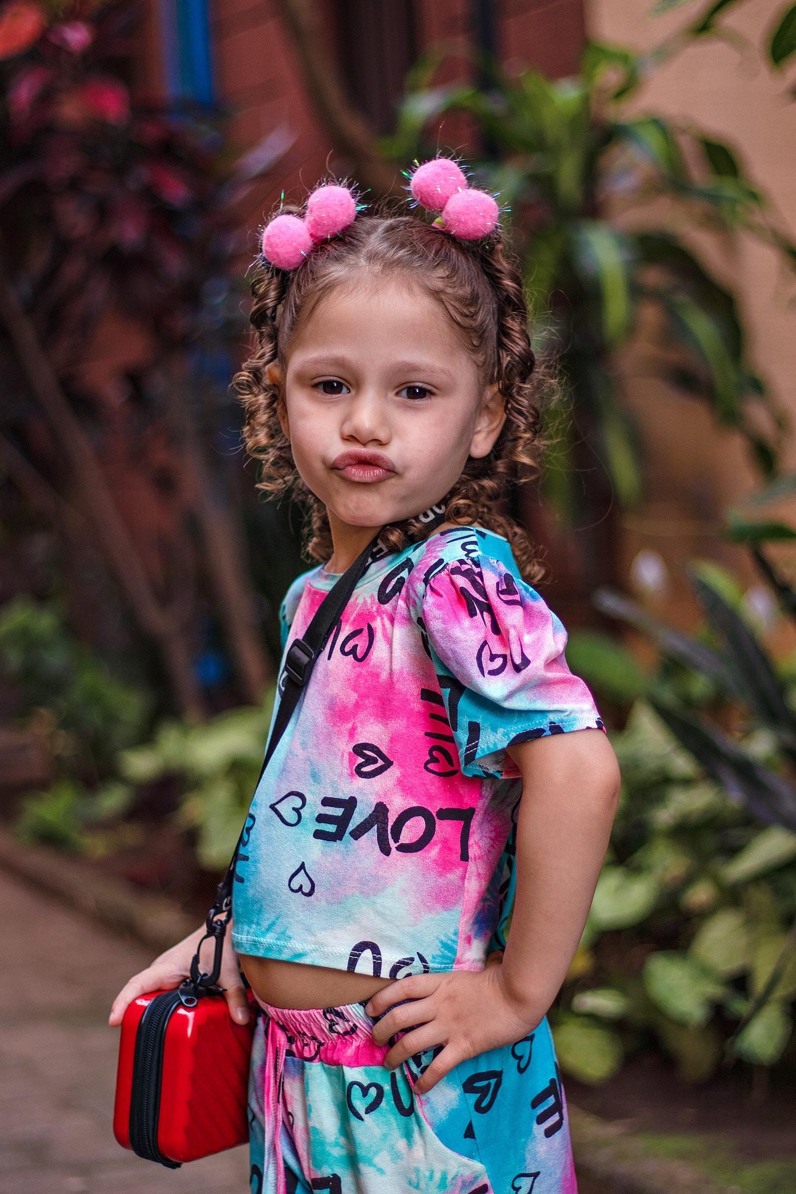 Little girl wearing pink pom poms hairstyle