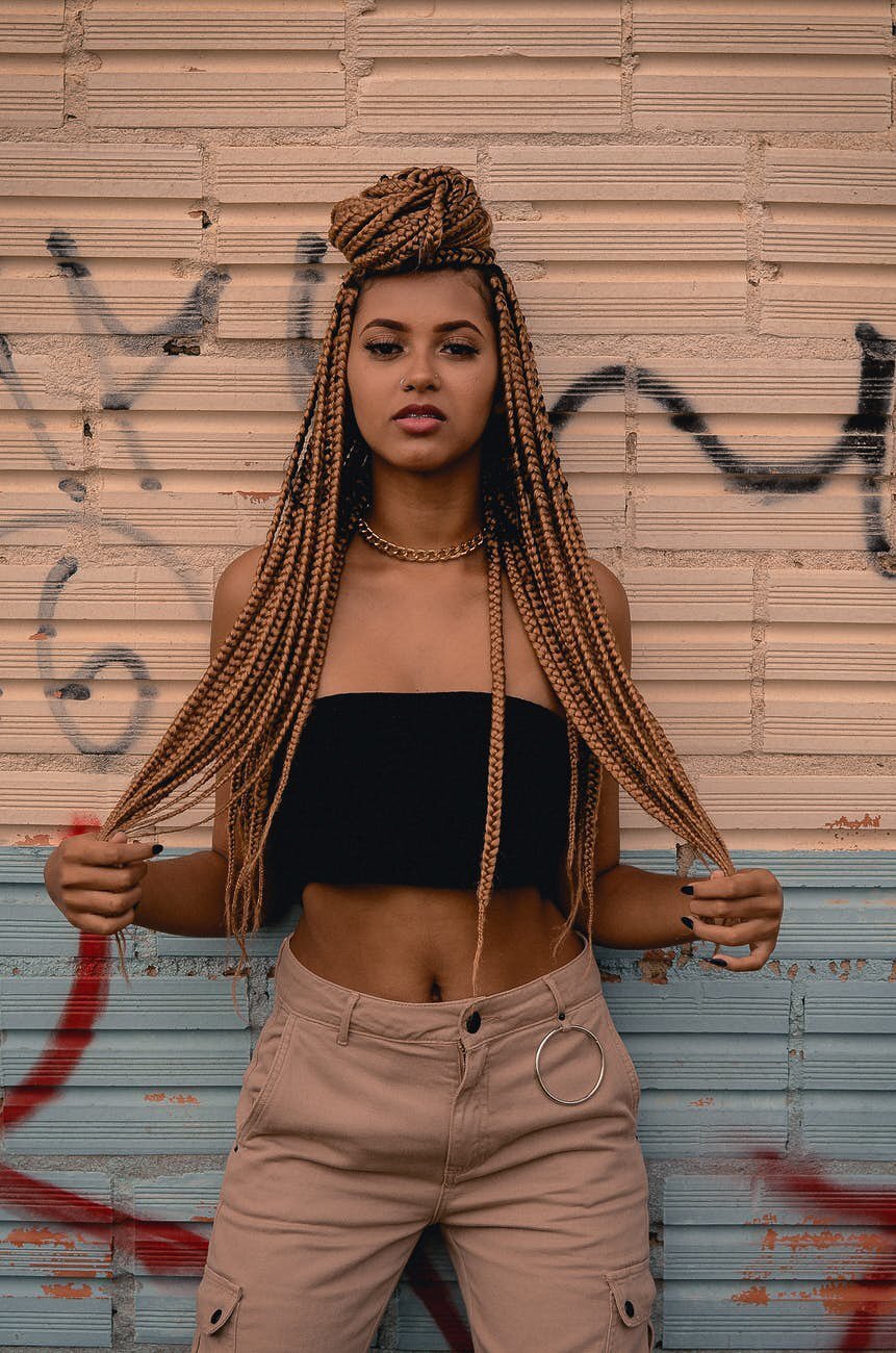 woman with long box braids honey coloured box braids top knot