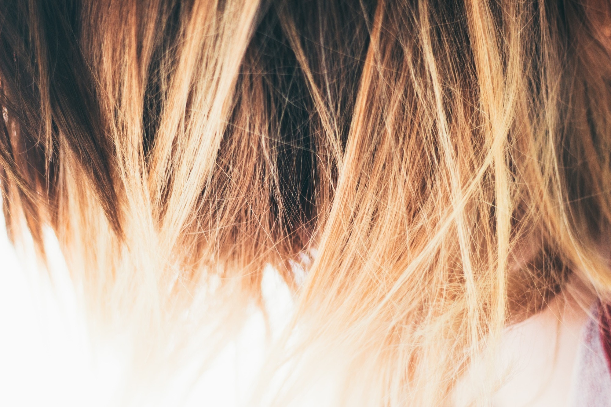 closeup shot of dark coarse hair with blonde ombre