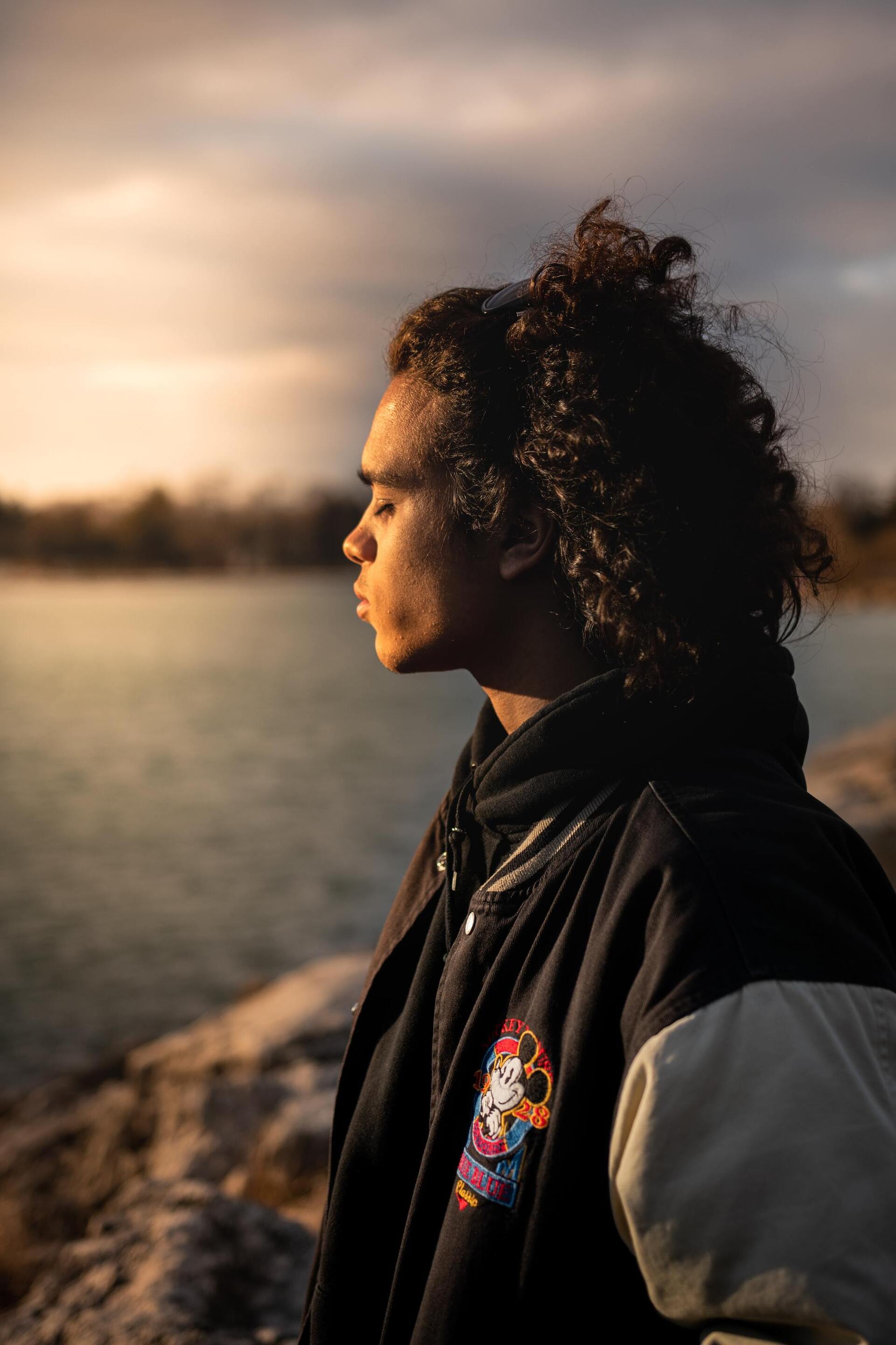 boy with long curly hair, tied half up