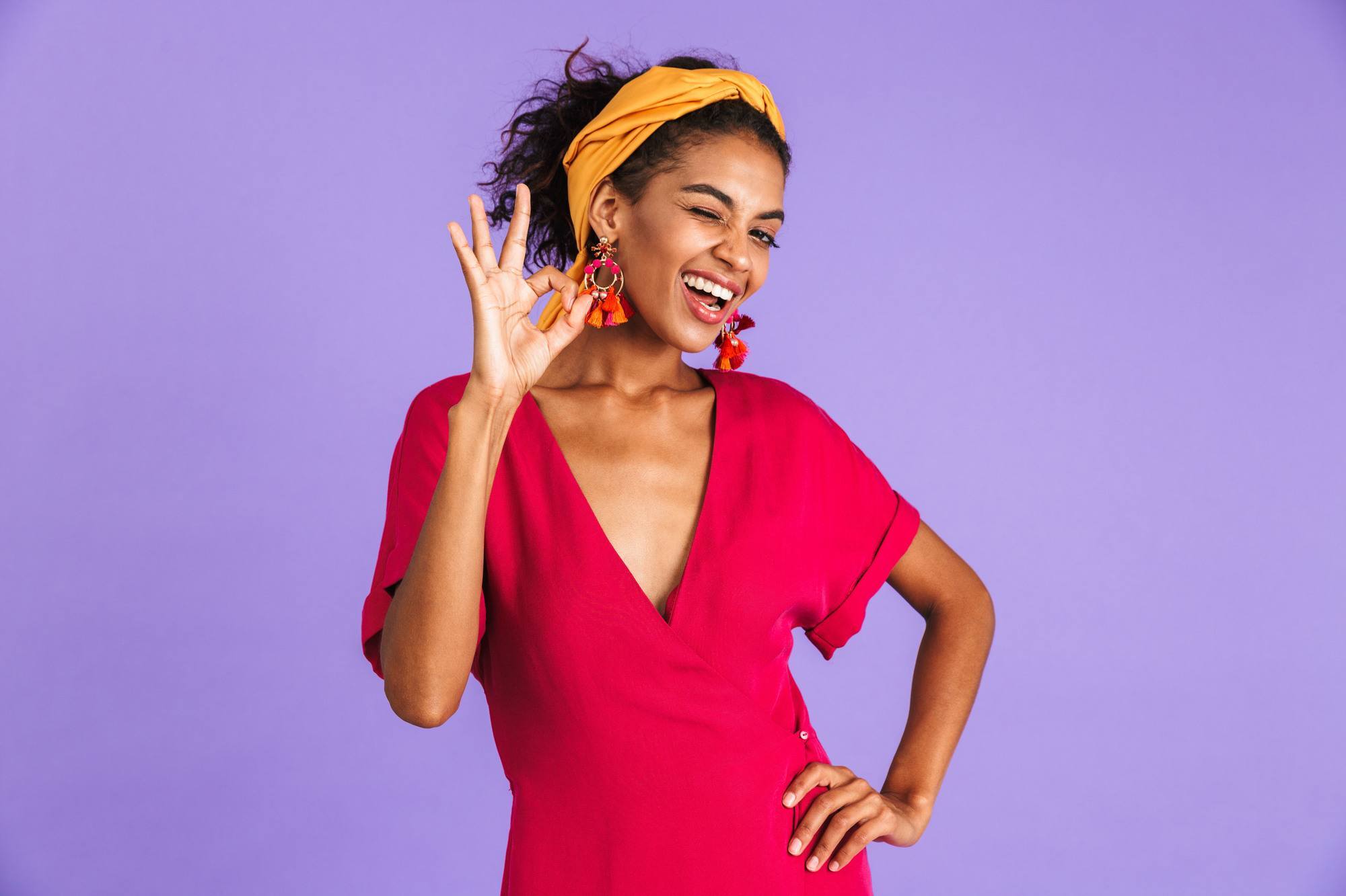 Image of cheerful happy woman wearing a hair band accessories smiling and showing ok sign isolated over violet background