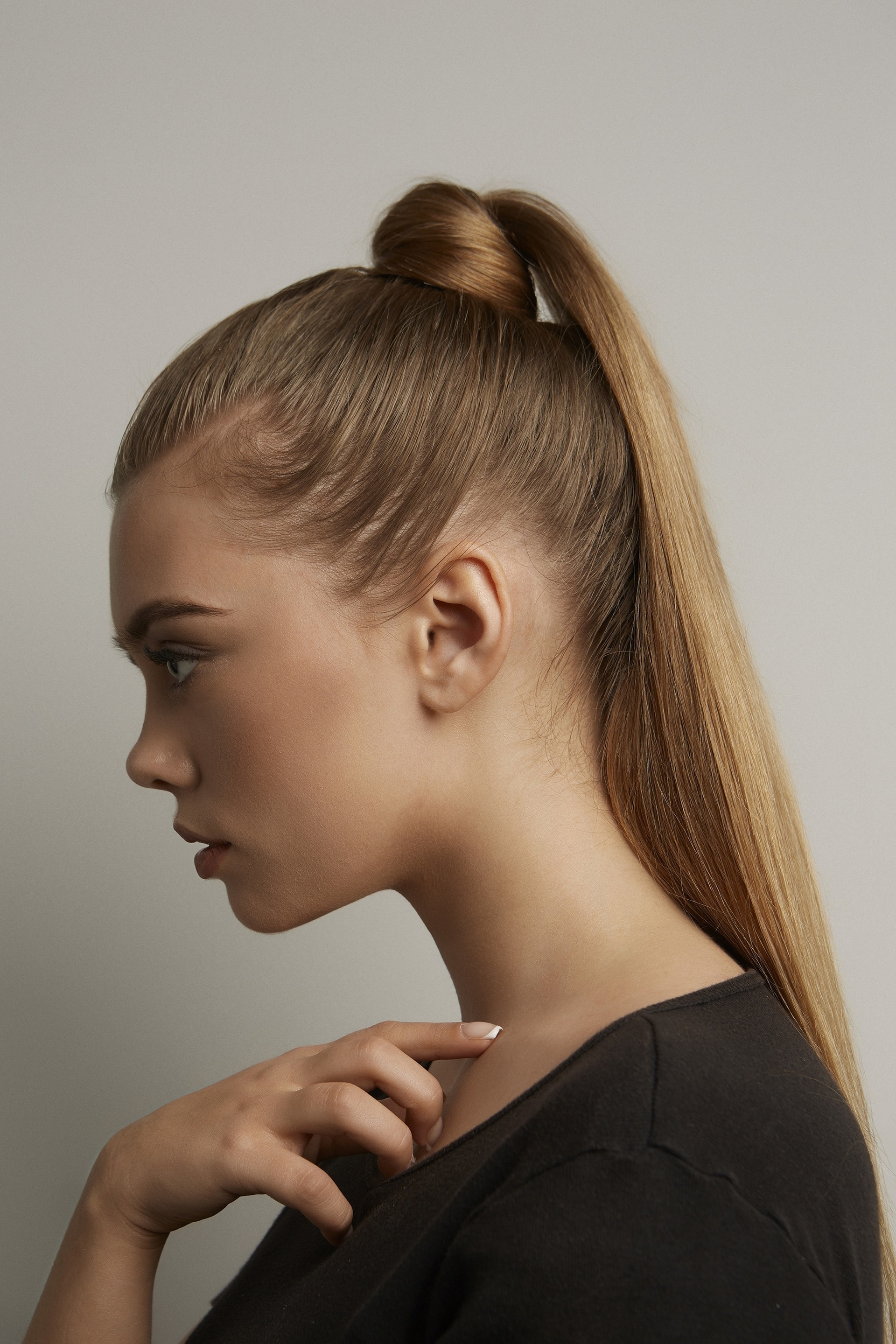 woman with a high, sleek ponytail and dark blonde hair