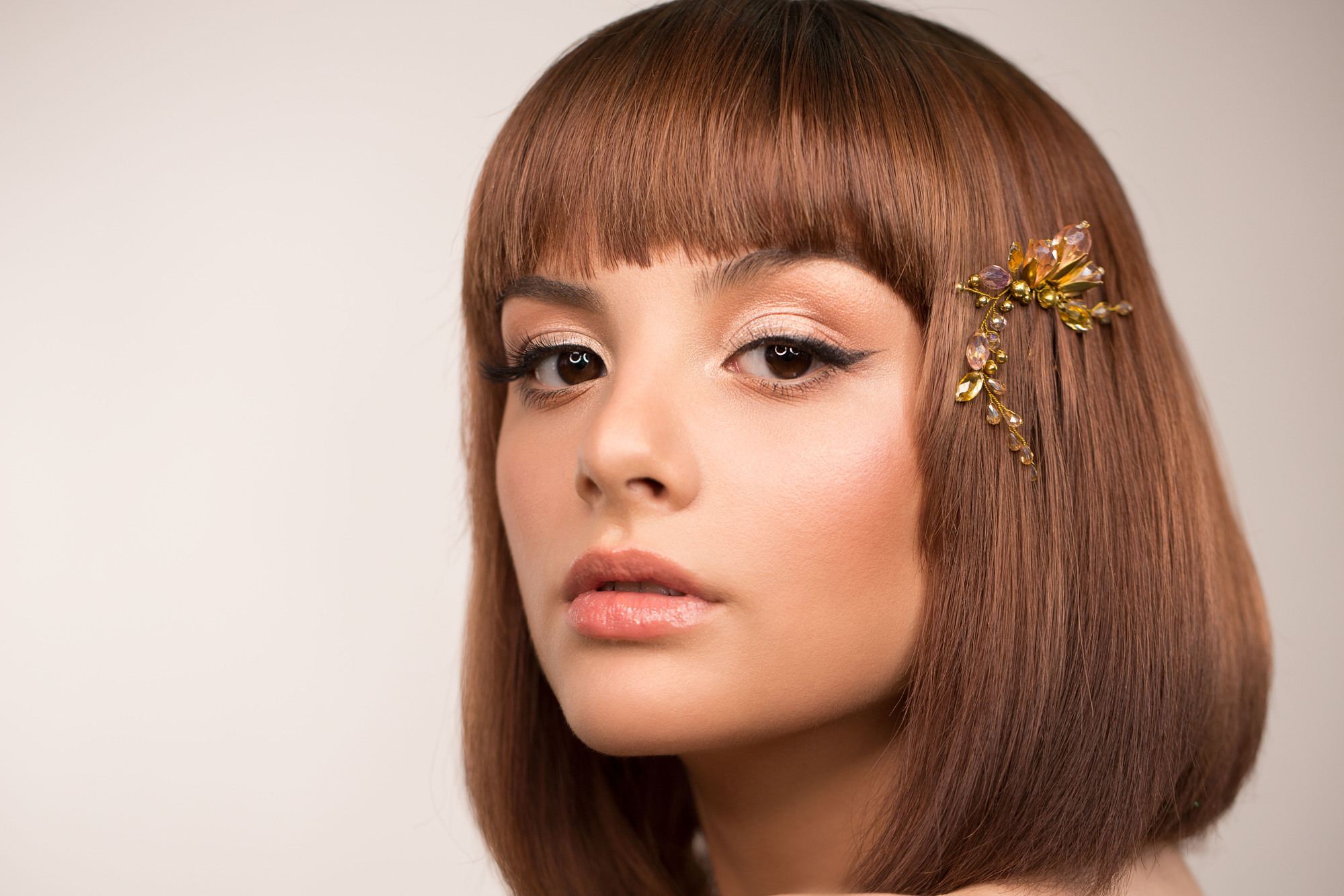 classic bob haircut with a straight fringe and bronze hair accessory