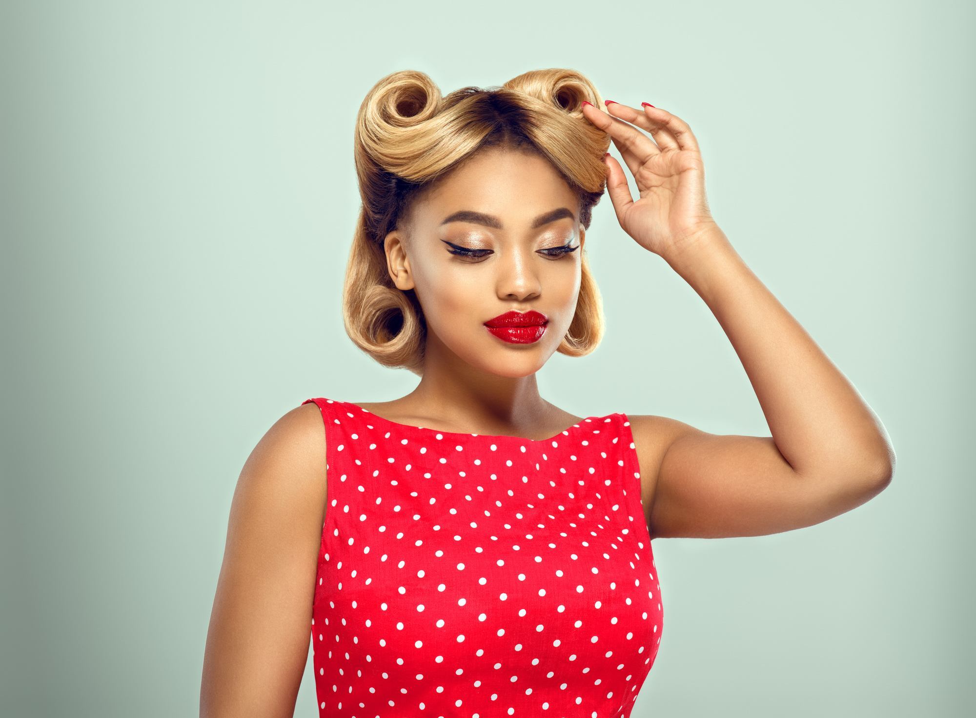 woman with dark blonde hair in victory rolls hairstyle