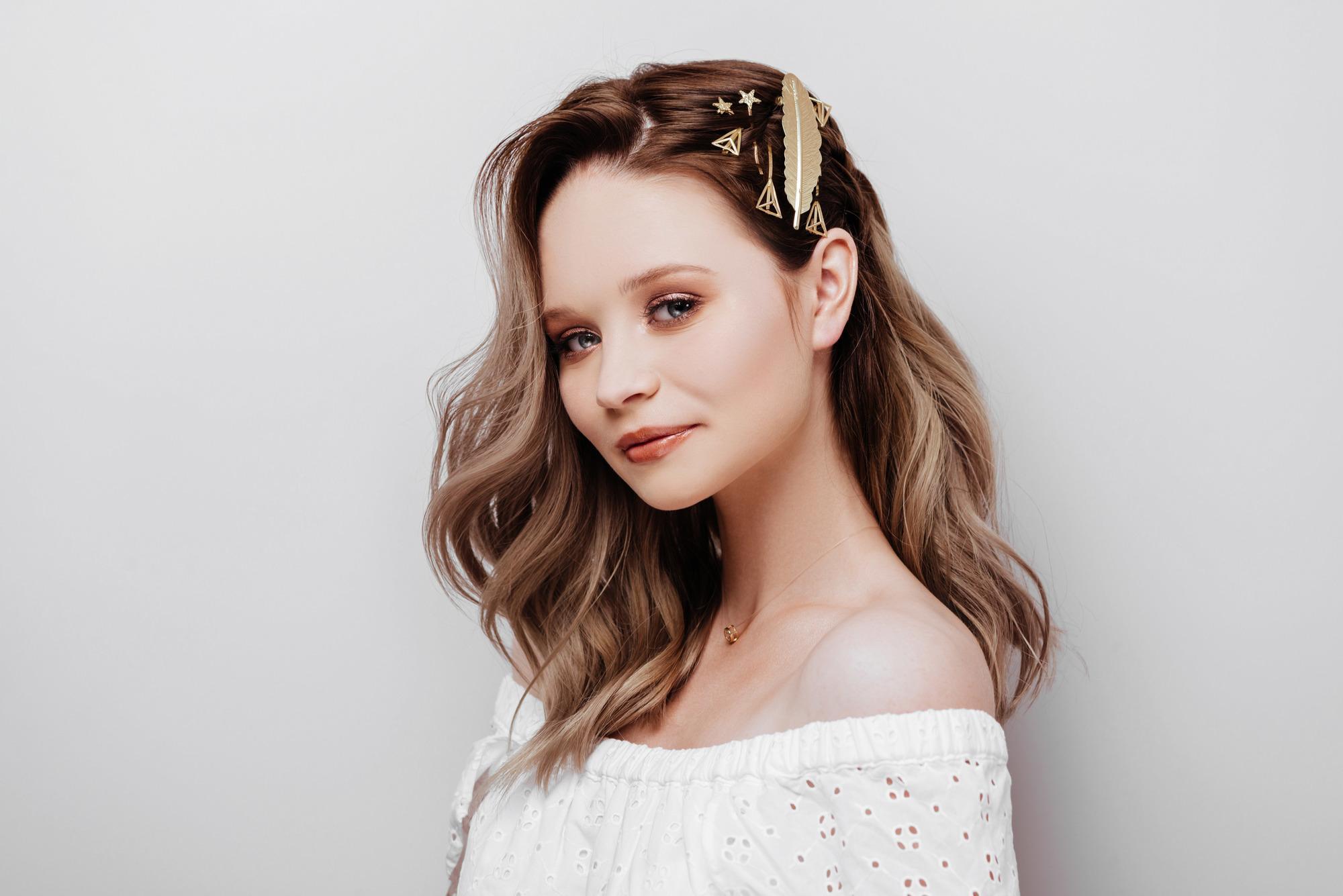 woman with medium length light brown wavy hair with bobby pins accessories