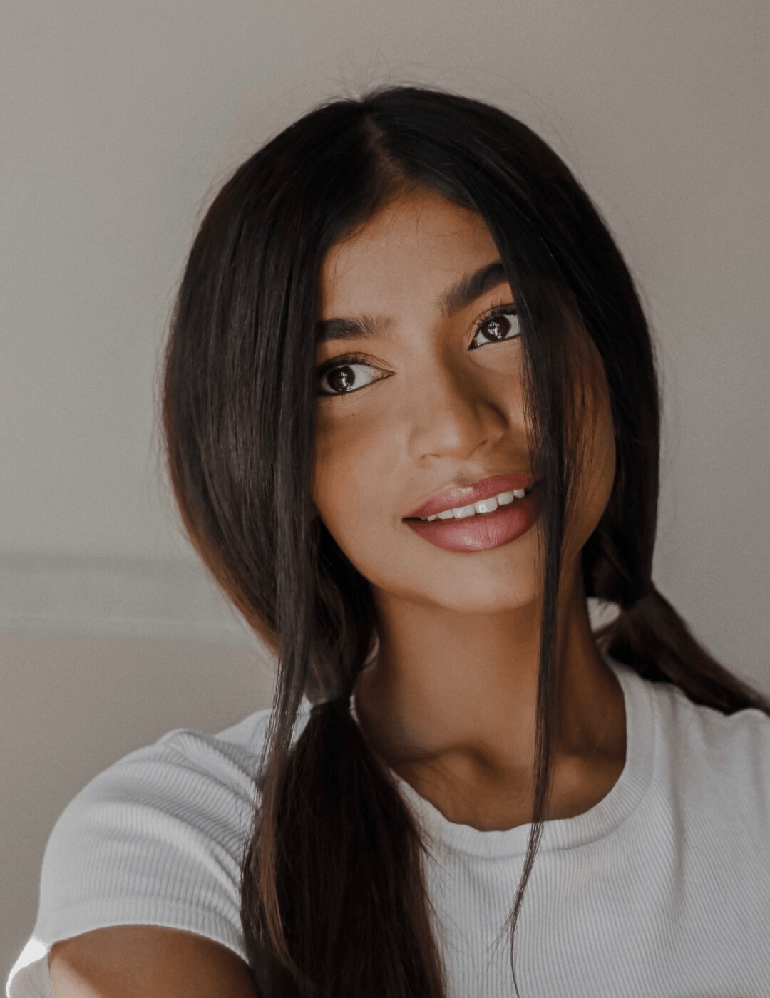 woman massaging dry shampoo into long brown hair
