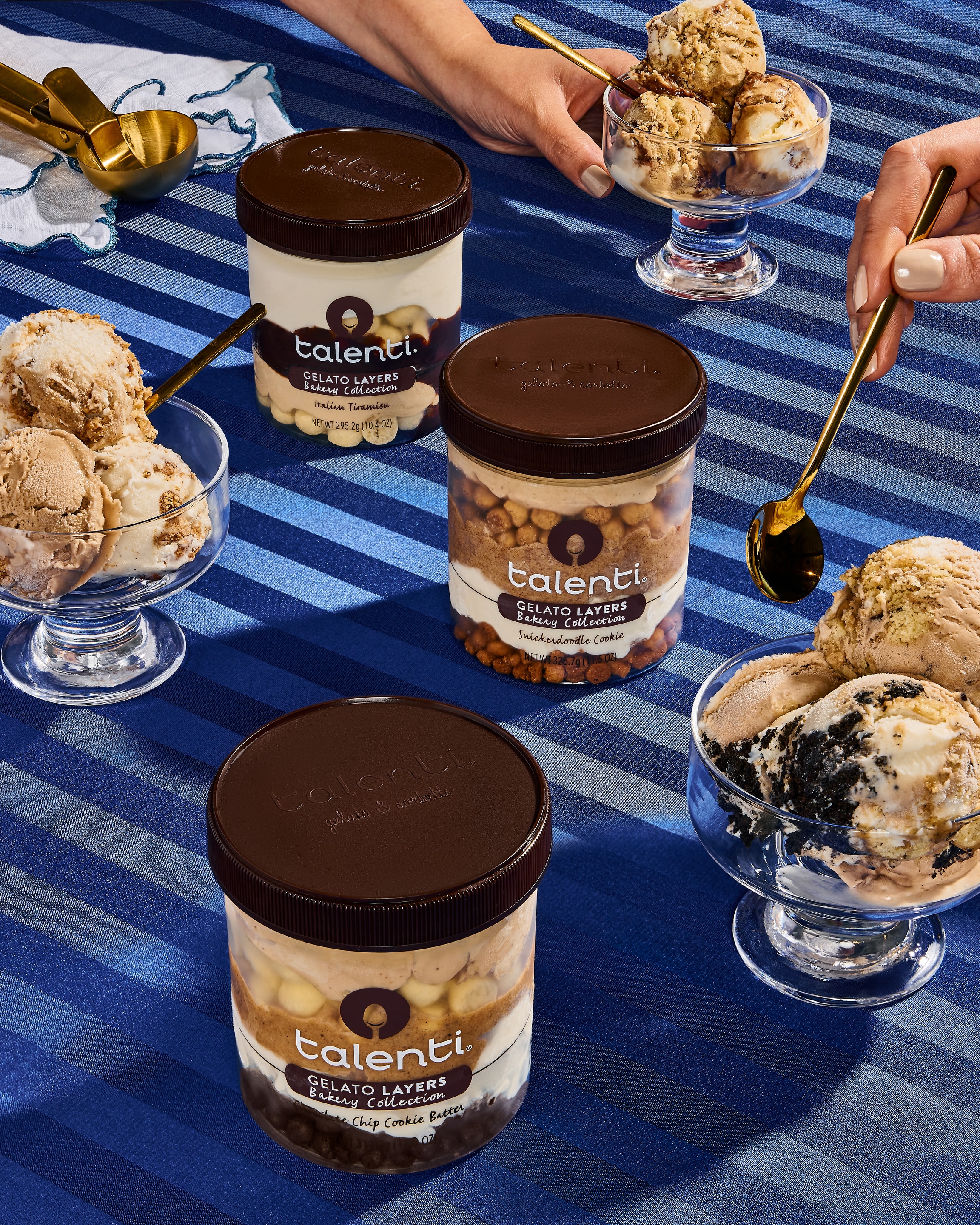 Talenti Bakery Collection Gelato Pints on a striped blue tablecloth, with gelato cups on the side.