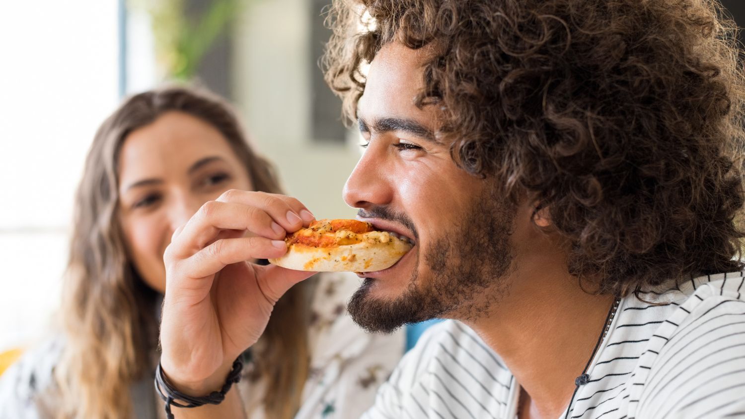 Young man eating pizza with no topping that will create body odor
