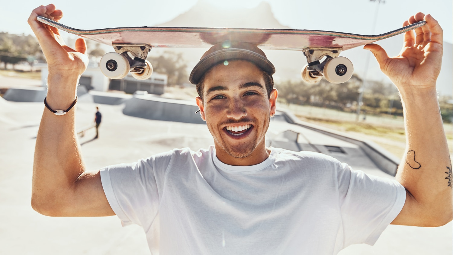 Young man with a skateboard who applied deodorant correctly with no sign of deodorant stains or sweat stains