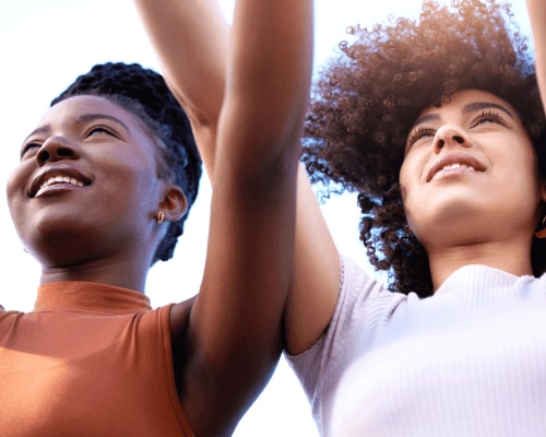 Two women outdoors showing their armpits