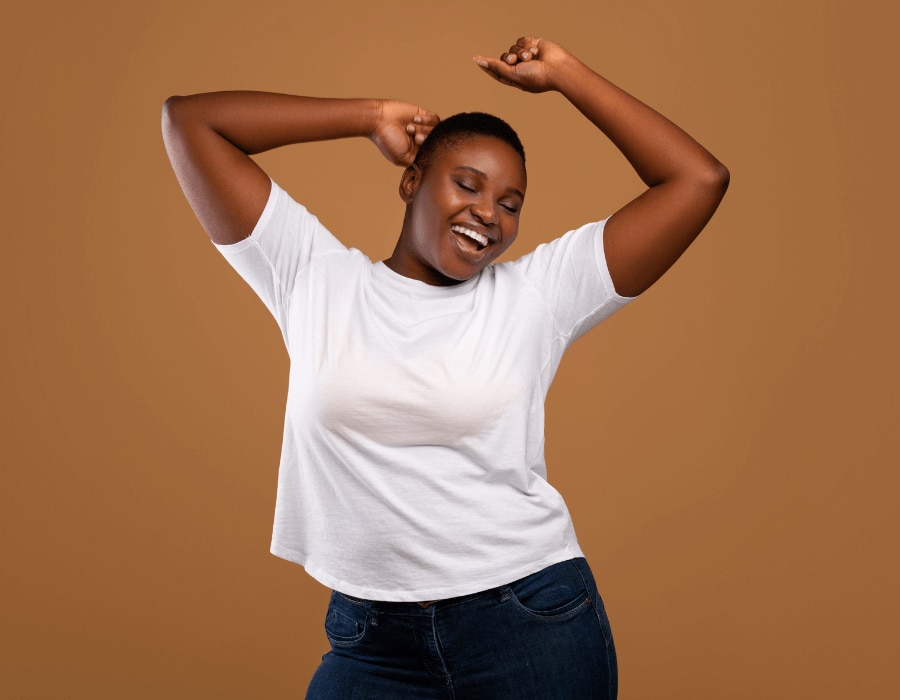 Smiling young woman with her arms raised