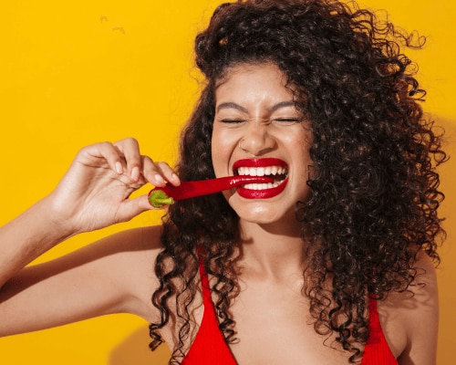 Woman taking a bite out of a chili