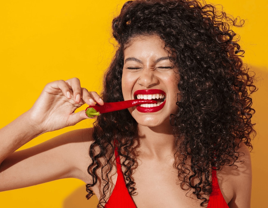 Woman taking a bite out of a chili