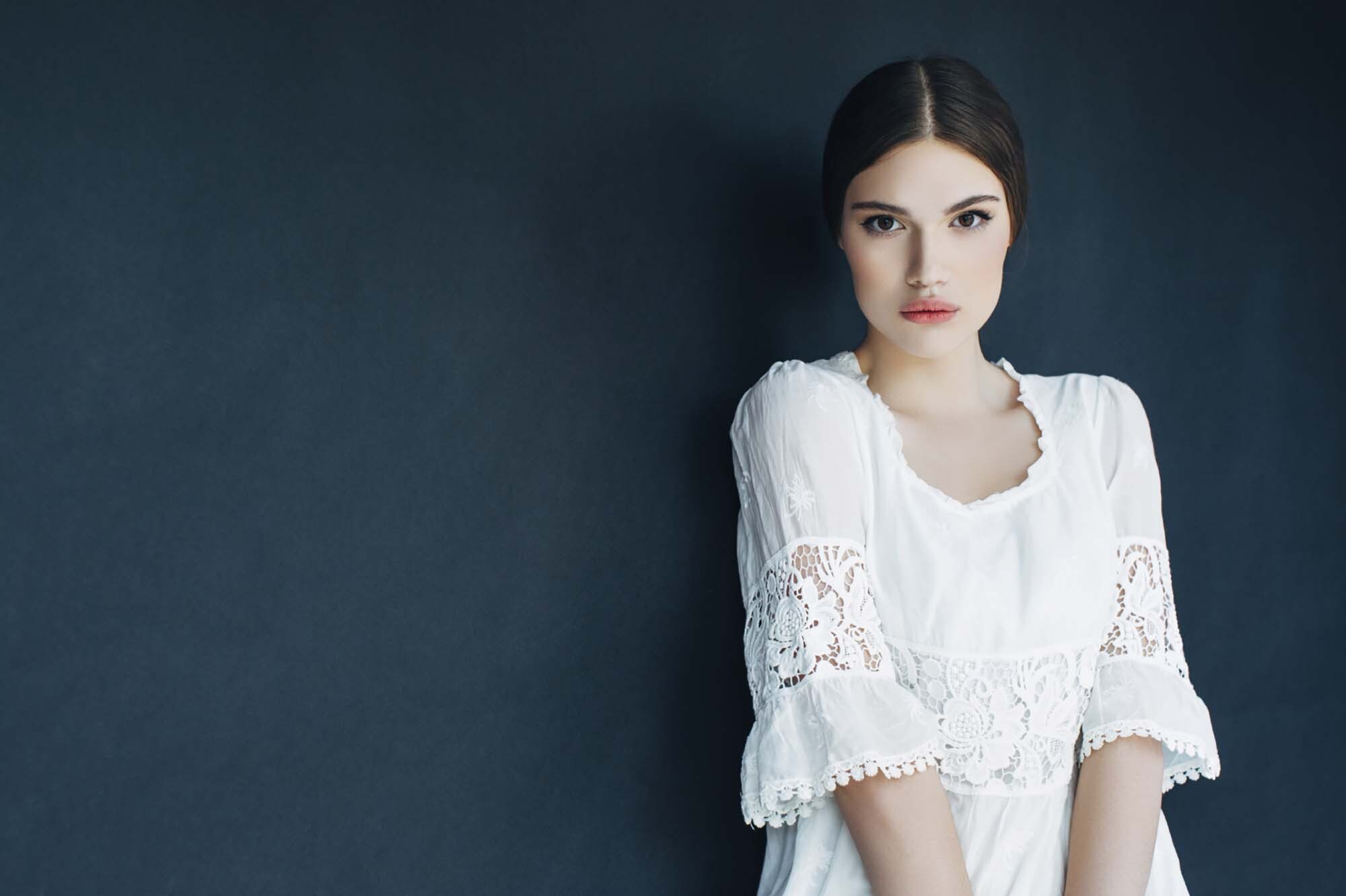 modelo usa cabelo lambido e repartido ao meio