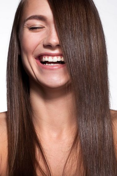 mulher com cabelo liso lingo castanho sorrindo