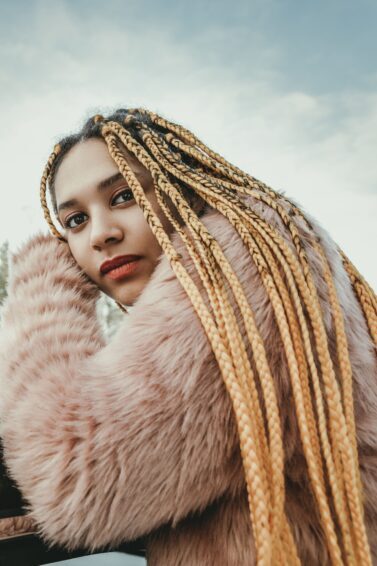mulher com box braids encostada em carro