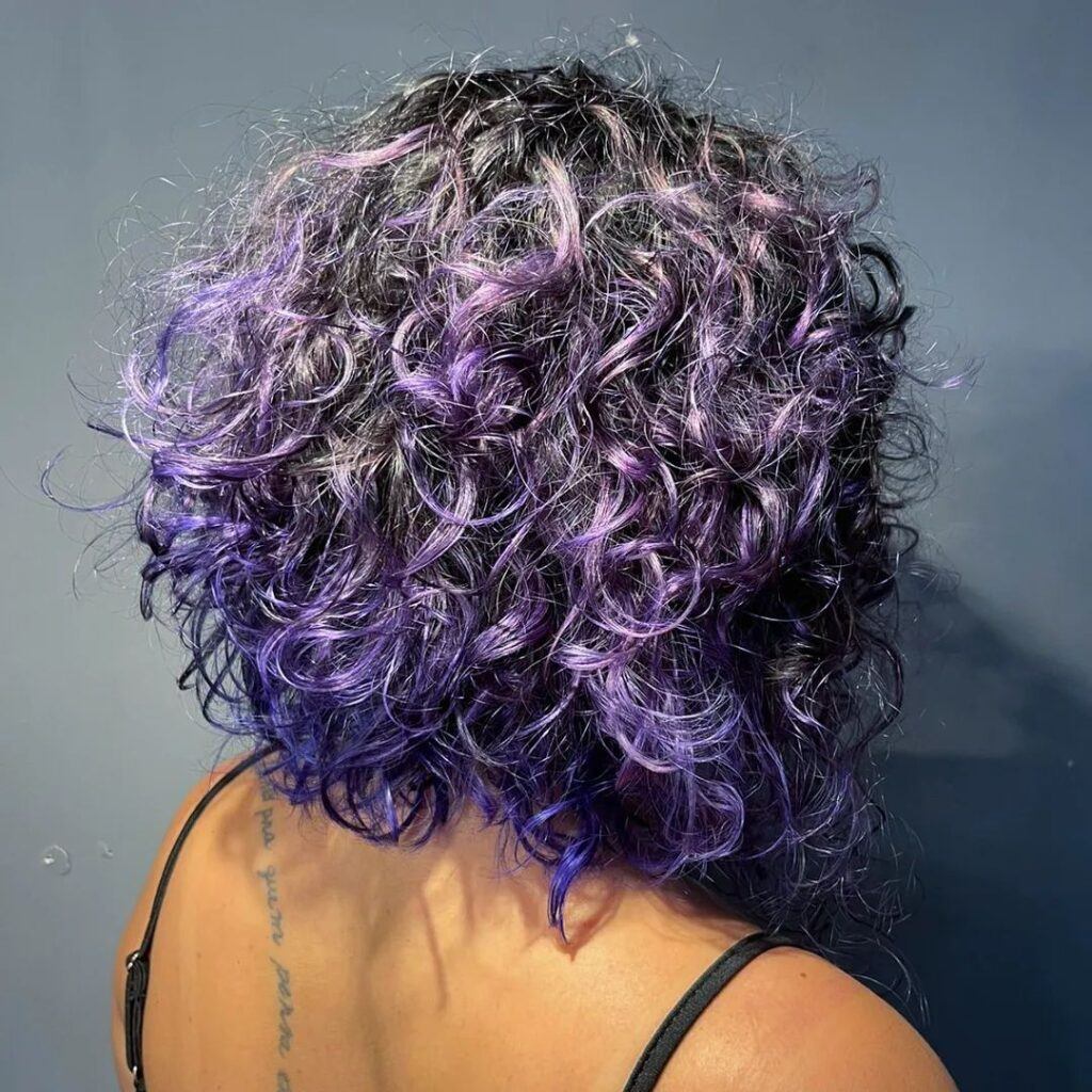 mulher de costas mostrando cabelo cacheado roxo