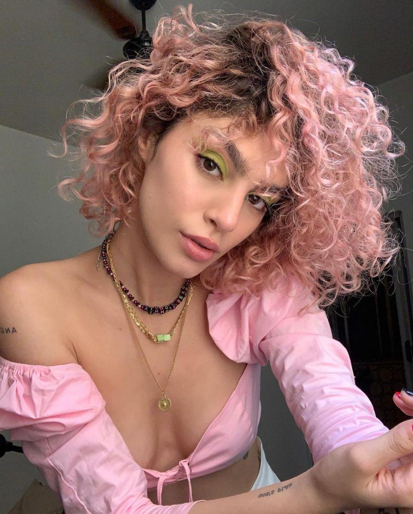 mulher com cabelo curto, rosa e cacheado