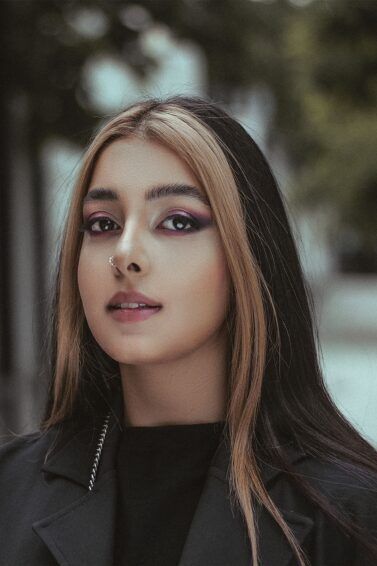 mulher com cabelo preto e loiro olhando para a câmera
