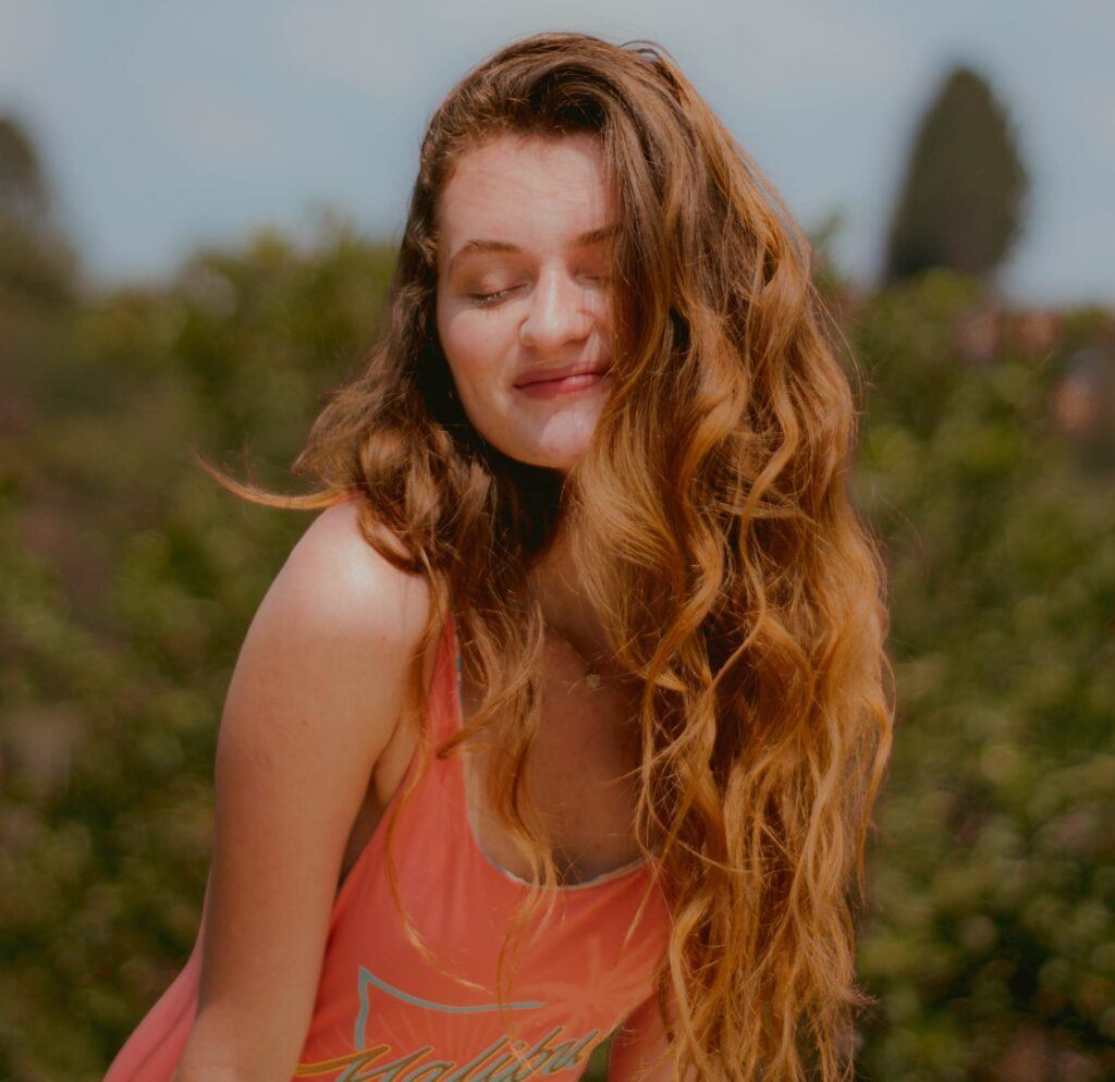 Mulher de cabelo castanho claro com fios clareados com camomila