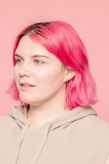 mulher com cabelo rosa curto
