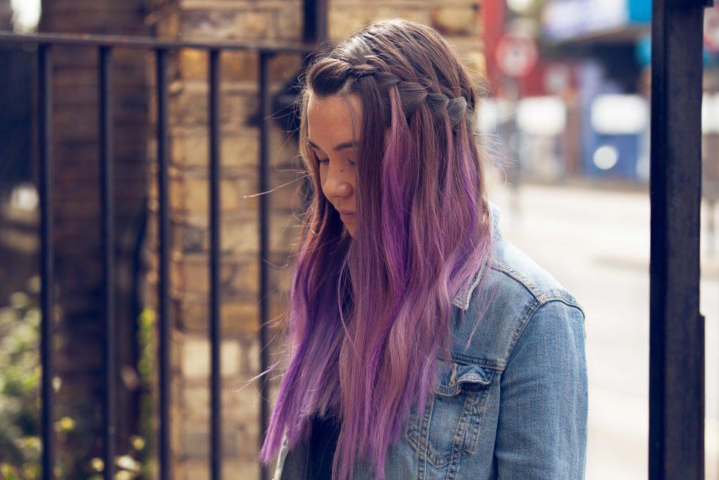Mulher com cabelo longo roxo com trança smipresa