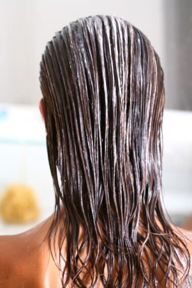 mulher de costas com cabelo longo com creme