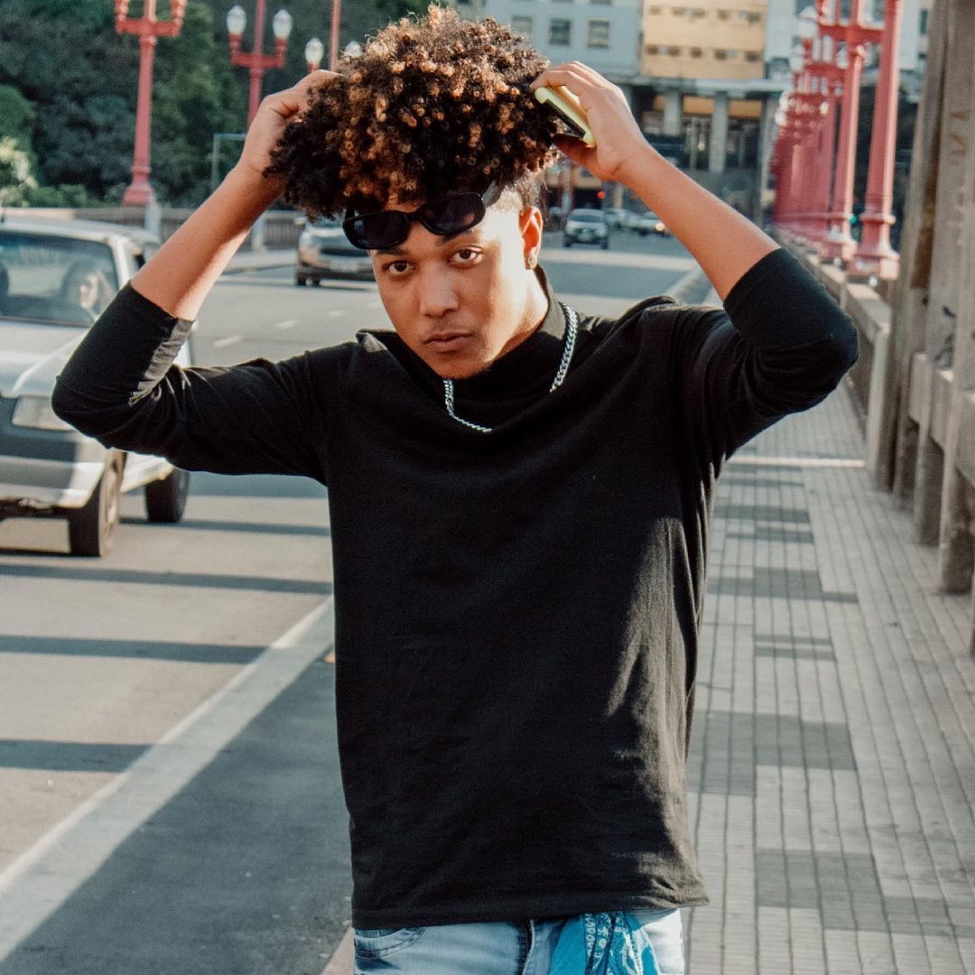 homem com cabelo cacheado com luzes