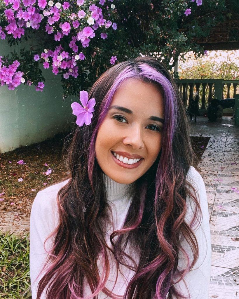 Mulher com mecha frontal roxa no cabelo longo