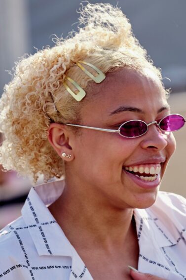 mulher sorrindo com cabelo cacheado loiro semipreso com tic-tac