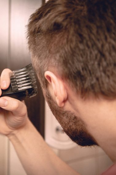 Homem usa máquina de cortar cabelo