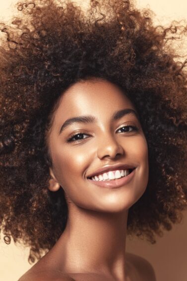 mulher sorrindo para foto em fundo bege